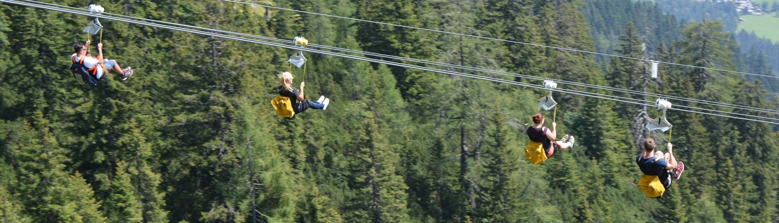 Personen fleigen mit der Zipline Stoderzinken über die Alpen