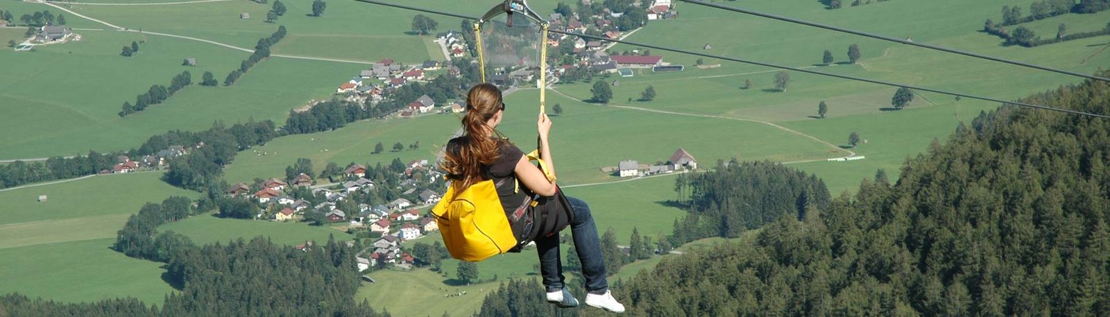 Mädchen fliegt mit der Zipline über die Alpen