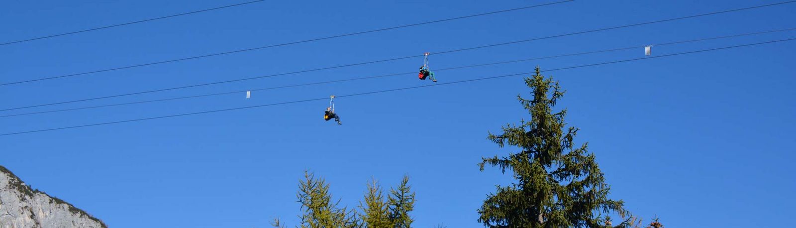 Personen fleigen mit der Zipline Stoderzinken über die Alpen